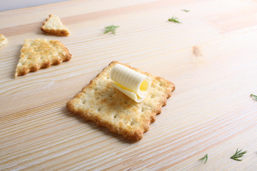 Cracker with butter on a wooden background