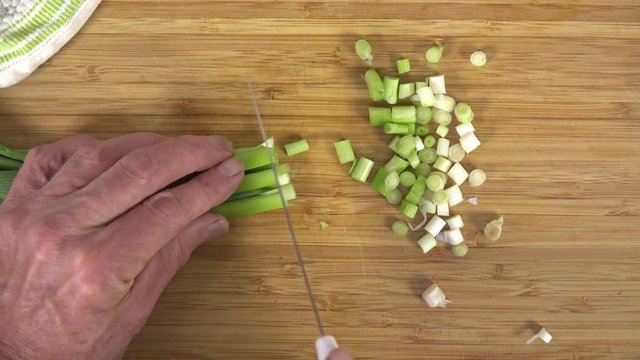 Time-lapse of chopping green onions, overhead view, 4K
