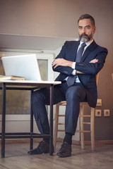 Senior older business man using a computer while sitting in a coffee shop