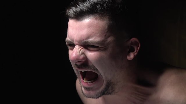 Side view as a man angrily screams