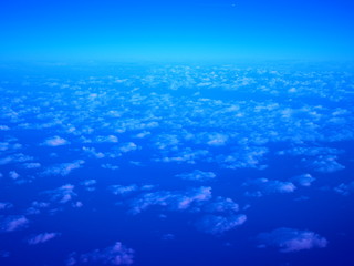 Deep dark blue early morning sky with very small white scattering, distributed fine carpet like clouds pattern, diagonal lines blending to horizon skyline above, and small clear area above background