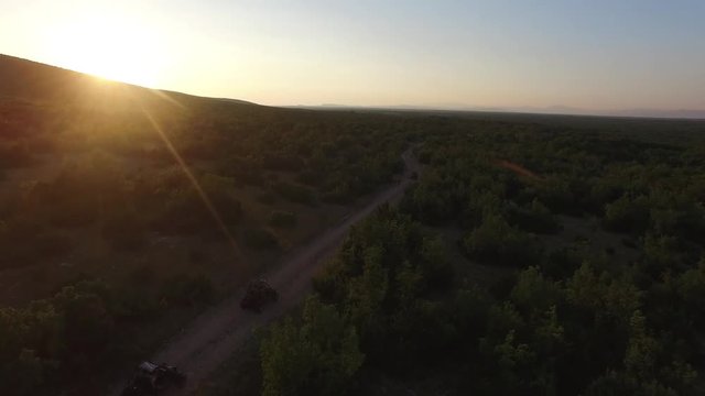 Drone shot of dune buggies driving on offroad on a dirt road on the countryside