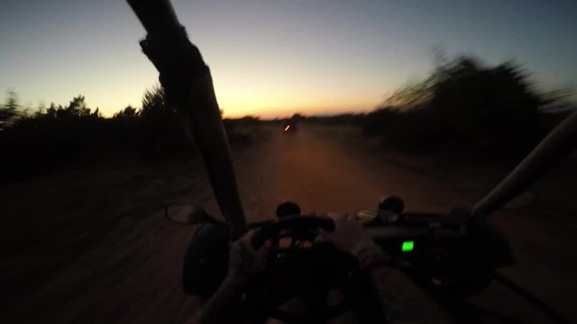 gopro shot of person driving dune buggy in the dark with lights on
