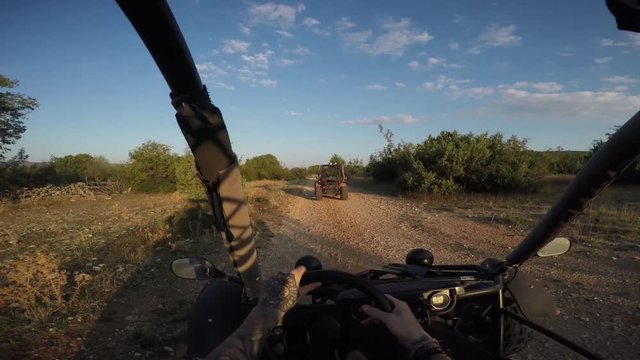 gopro shot of young man driving dune buggy in the sunset