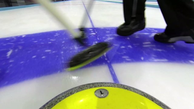 Curling stone rolling on ice POV