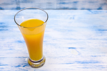 oranges and orange juice on a wooden light background