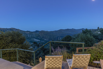Wooden Deck outdoor patiio at night with two chairs and amazing hillside view