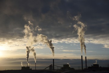 Sunset silhouette of smokestack carbon emission plumes at a coal fired power plant in Wyoming