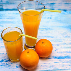 oranges and orange juice on a wooden light background