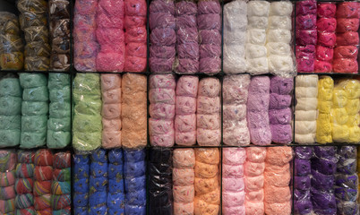 Colorful of yarns ball arranged on shelf.