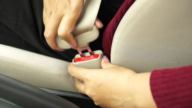  woman hand fastening a seat belt before driving her car ,safety first concept  