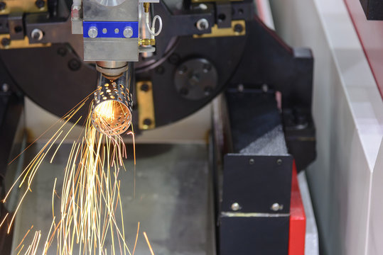 The laser cutting machine cutting the stainless tube.The sparking light from laser cutting machine.