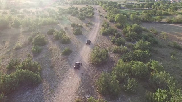 Drone shot of dune buggies driving on offroad on a dirt road