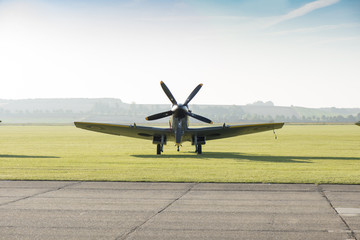 Front View of Classic Spitfire Aircraft by a Runway - obrazy, fototapety, plakaty
