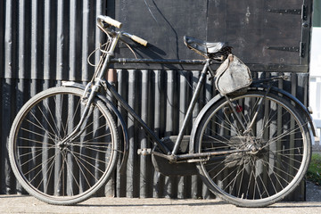Naklejka na ściany i meble Bicycle on a Background of Galvanized Iron Sheets Shot Outdoors