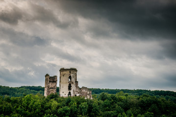 two towers of the old castle. Ruins of the palace side. Chervonogradsky Castle, Ukraine. Clouds in the sky.
