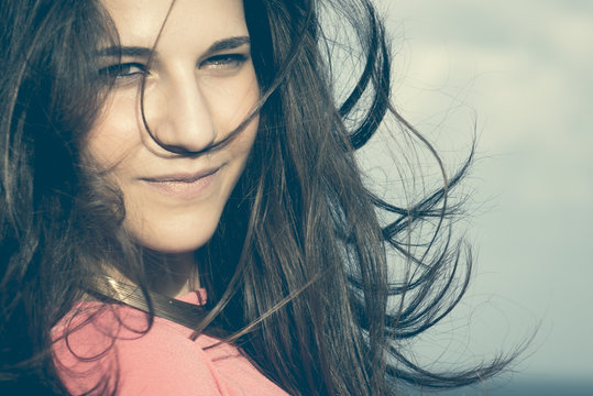 Close up of a 18Y old girl in a rural location, sea at the background. Location: Plemmirio , Siracusa, in Sicily. 