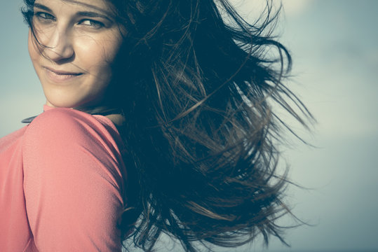 Close up of a 18Y old girl in a rural location, sea at the background. Location: Plemmirio , Siracusa, in Sicily. 