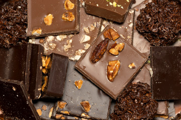 square hand made pieces of chocolate ornated with almonds, nuts and chestnuts.