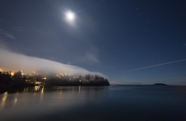 Fog covering the land on a starry night with moon lit