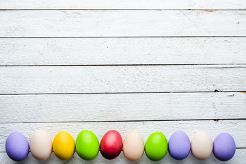 Easter background, seasonal colorful painted easter eggs on wooden white boards