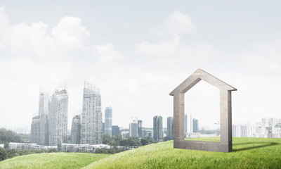 Fototapeta premium Conceptual image of concrete home sign on hill and natural landscape at background