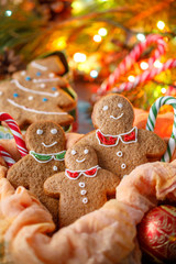 Still life with cookies in the form of little people and Christmas trees on the background of a glowing garland. Family celebrating the new year.