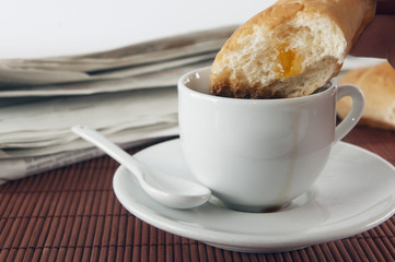 Breakfast concept, jam croissant drenched in a cup of coffee