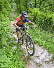 junge Frau befährt einen steilen treppenartigen Trail