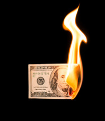 a hundred dollars burn in a fire on a black background