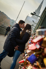 Obraz na płótnie Canvas Lovers kissing on a bridge full with locks