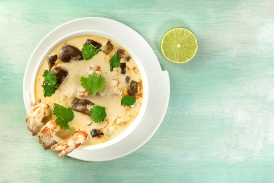 Tom Yam, traditional Thai soup with shrimps and mushrooms, on teal