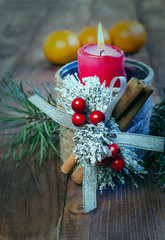 Candle, spruce branches and mandarins on a wooden background