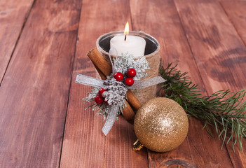 Candle and Christmas tree decorations on a wooden background