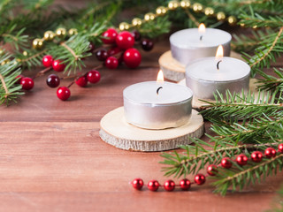 Hot candle against the background of spruce branches