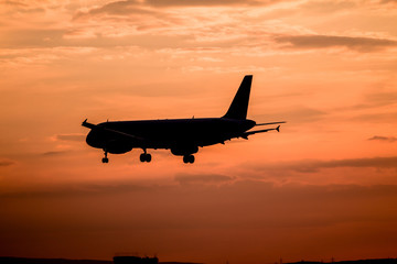 Fototapeta na wymiar Airplane landing at sunset
