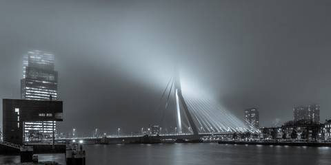 view on the Erasmusbridge from the Stieltjesstraas by night and fog in black and white