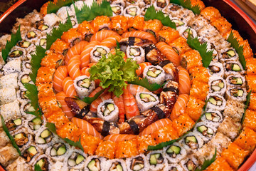 different types of sushi are stacked on a round dish Variety of japanese sushi rolls.