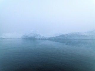 Icebergs in foggy day on Arctic Ocean in Greenland