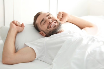 Morning of handsome man lying in bed at home
