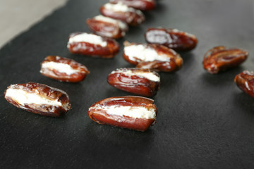 Ripe dates stuffed with goat cheese on slate plate