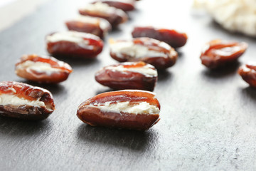 Ripe dates stuffed with goat cheese on slate plate
