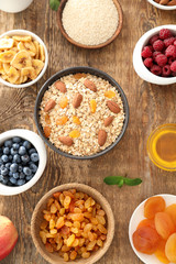 Oatmeal flakes and many different toppings on wooden background