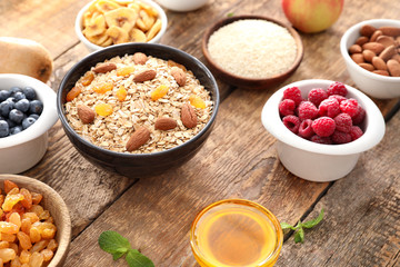 Oatmeal flakes and many different toppings on wooden background