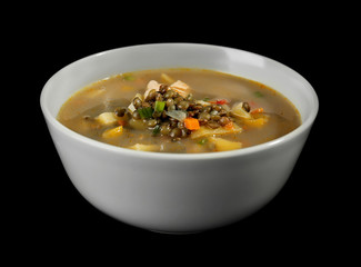 Bowl with tasty lentil soup on black background