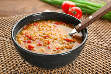 Bowl with tasty lentil soup on table