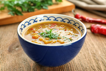 Bowl with tasty lentil soup on table
