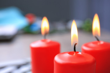 Red burning candles on blurred background