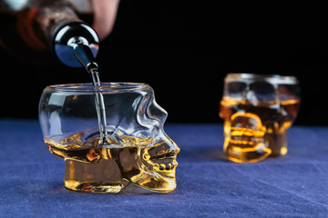 strong alcoholic drink poured into a glass made in the shape of the skull