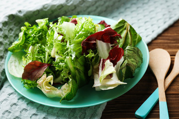 Plate with fresh salad on table